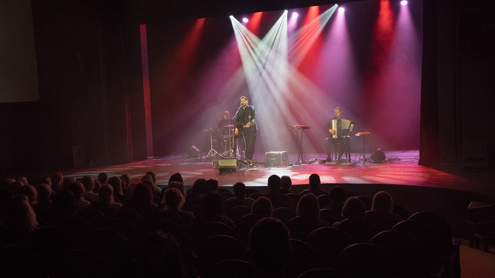 A duo performing on stage in pink light