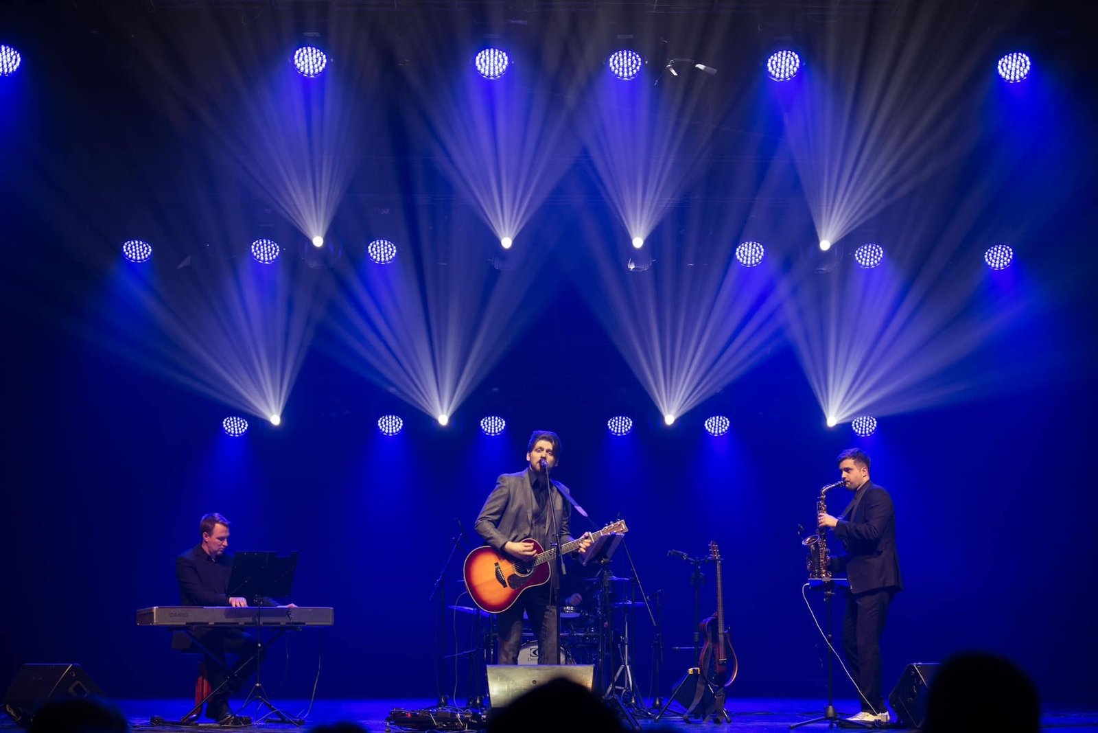 The band performing under blue stage lights