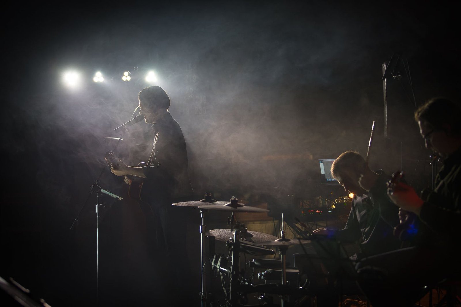 The band on stage amid smoke and spotlights
