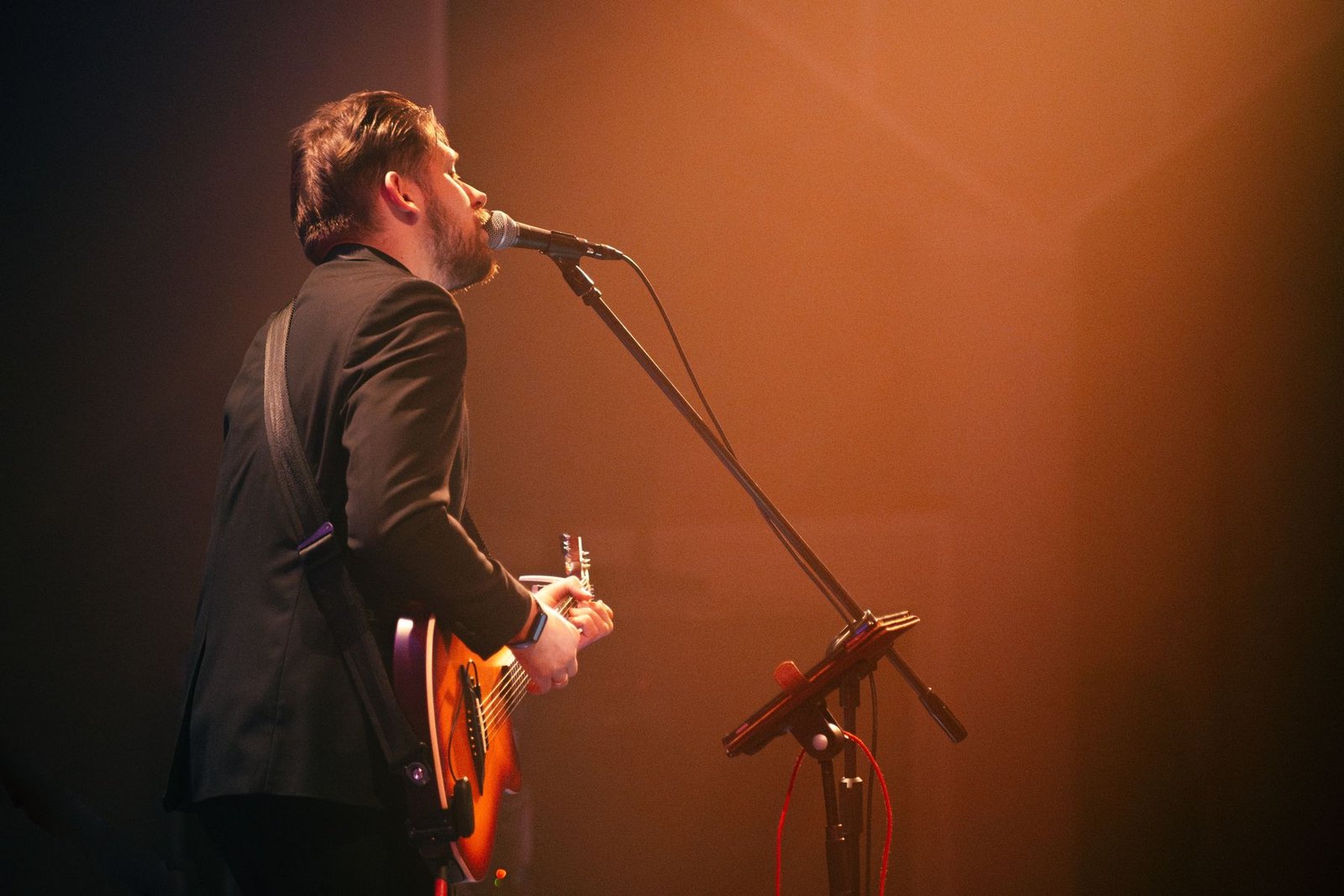 Justinas Stanislovaitis singing in concert in warm stage light